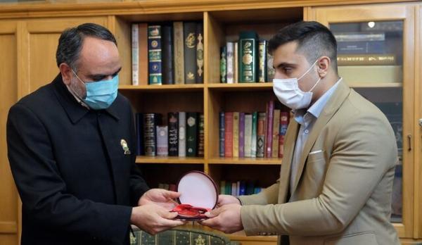 اهدای مدال قهرمان وزنه برداری آسیا به موزه آستان قدس رضوی